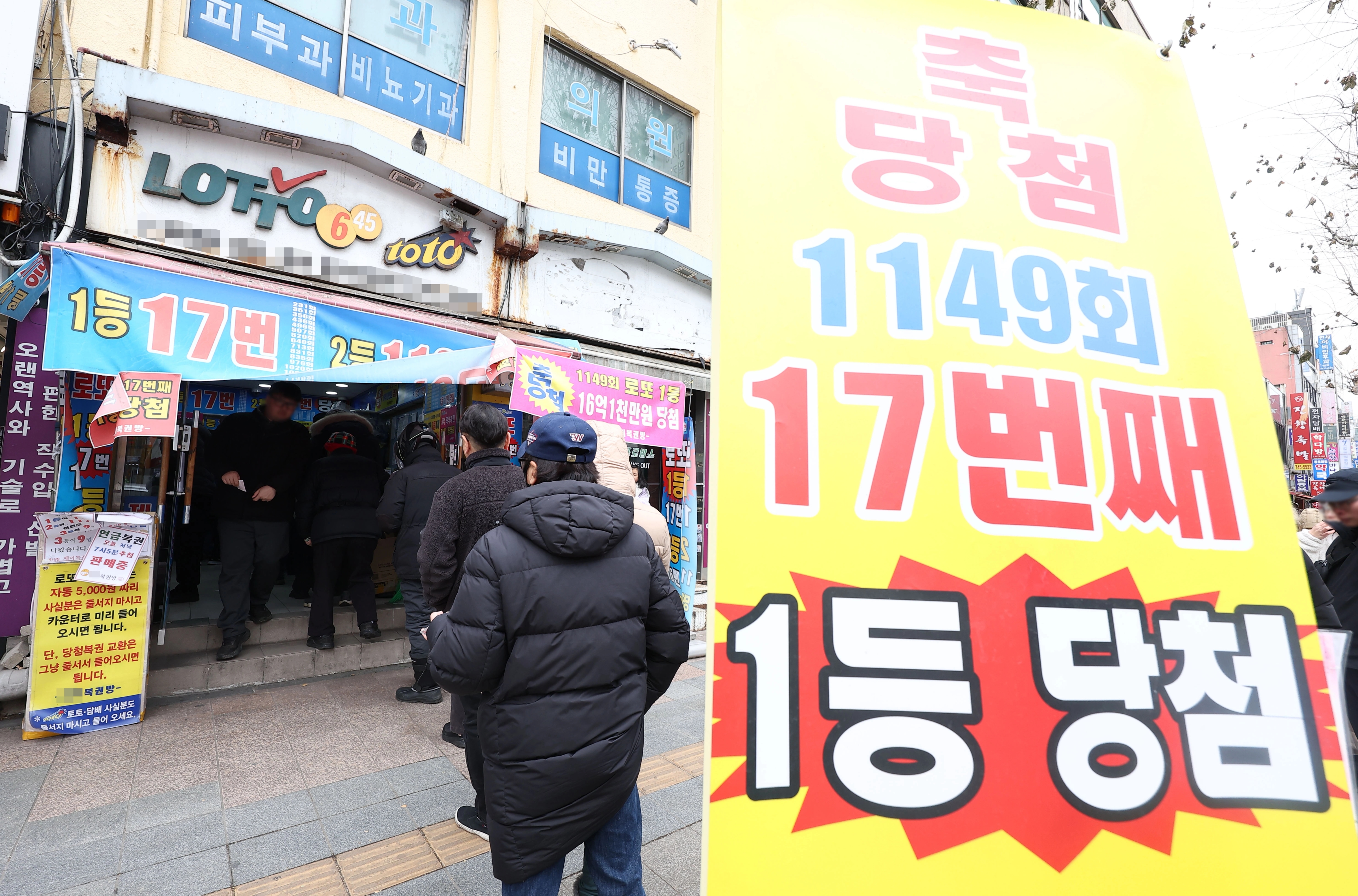 로또복권이 지난해 6조원 가까이 팔리며 또 역대 최대 판매를 기록한 가운데 30일 오후 '로또명당'으로 알려진 서울 종로구의 한 복권판매점 앞에 시민들이 복권 구입을 위해 줄을 서 있다. / 연합뉴스