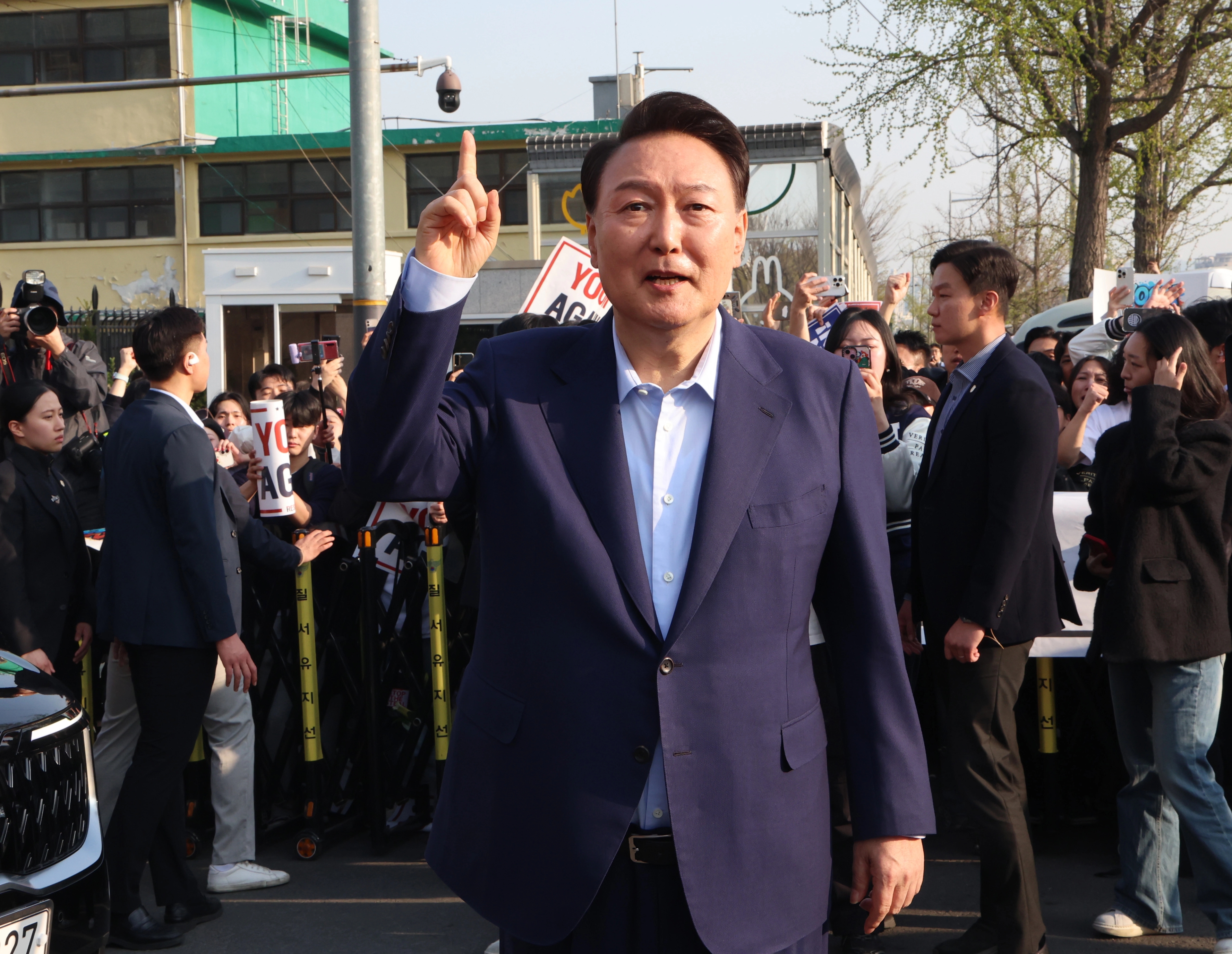 윤석열 전 대통령이 11일 오후 서울 용산구 한남동 대통령 관저를 떠나기 앞서 정문 앞에서 지지자들과 인사를 하고 있다. / 연합뉴스