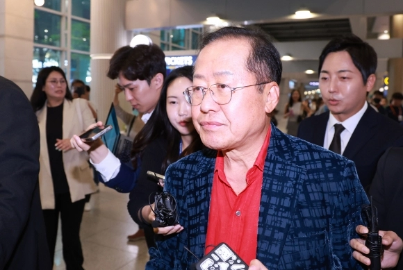 홍준표 전 대구시장이 17일 인천국제공항 제1여객터미널을 통해 귀국, 취재진과 인터뷰를 마친 뒤 이동하고 있다. / 연합뉴스
