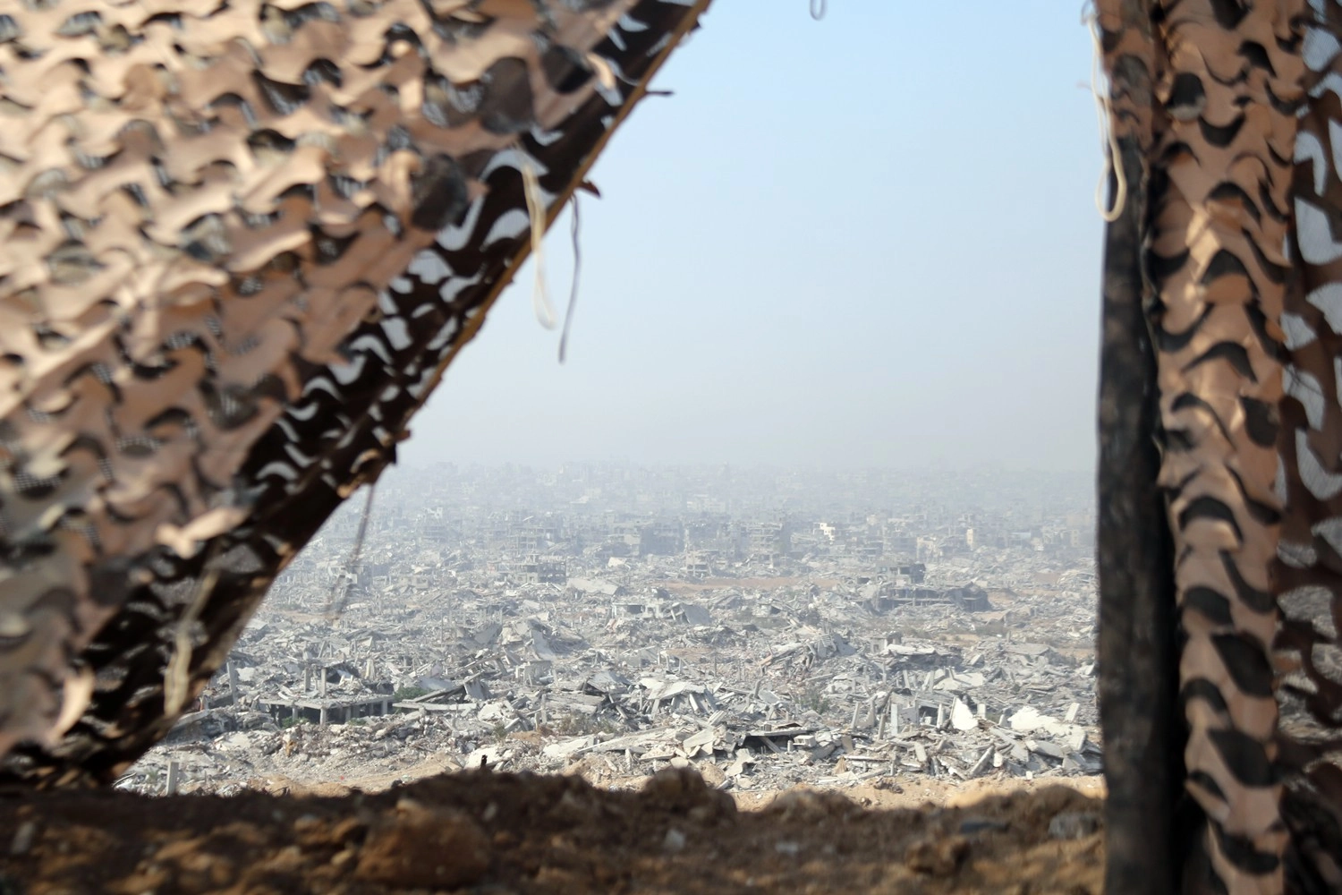 5일(현지시간) 가자지구 셰자이야의 이스라엘군 주둔지에서 위장막 사이로 바라본 가자시티. 2025.11.6